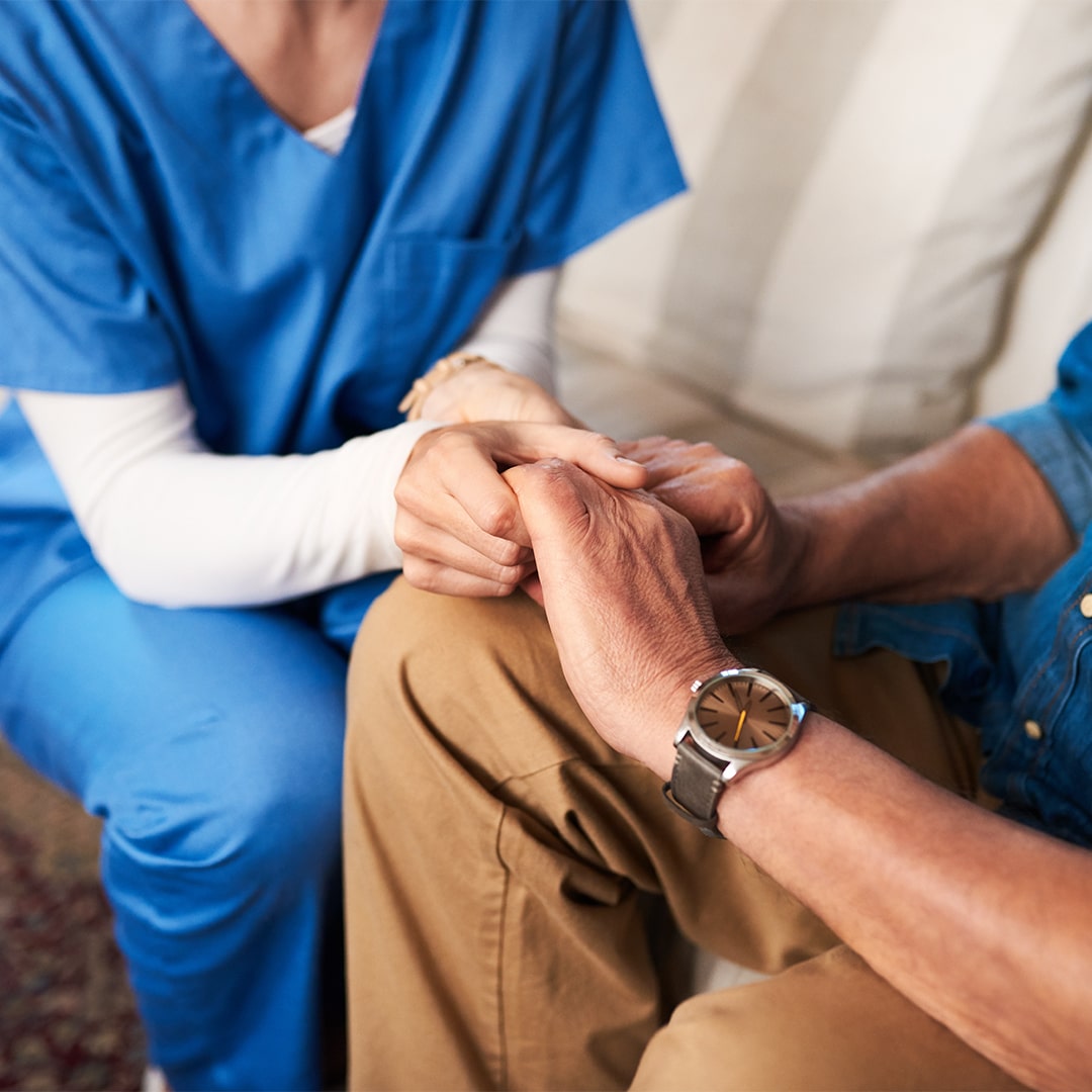 Main dans la main, infirmière et gros plan à domicile pour le soutien, l'empathie et les soins palliatifs. Réconfort, soignant et personne bienveillante, confiante et aidante pour la guérison d'un patient atteint de cancer.